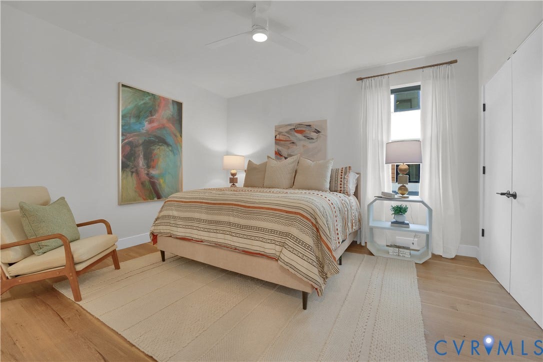 4506 1/2 Grove Avenue, Munford On Grove, Richmond, VA 23221 Bright interior space featuring light wood-finish flooring, a ceiling fan with integrated lighting, and a prominent window with sheer white curtains