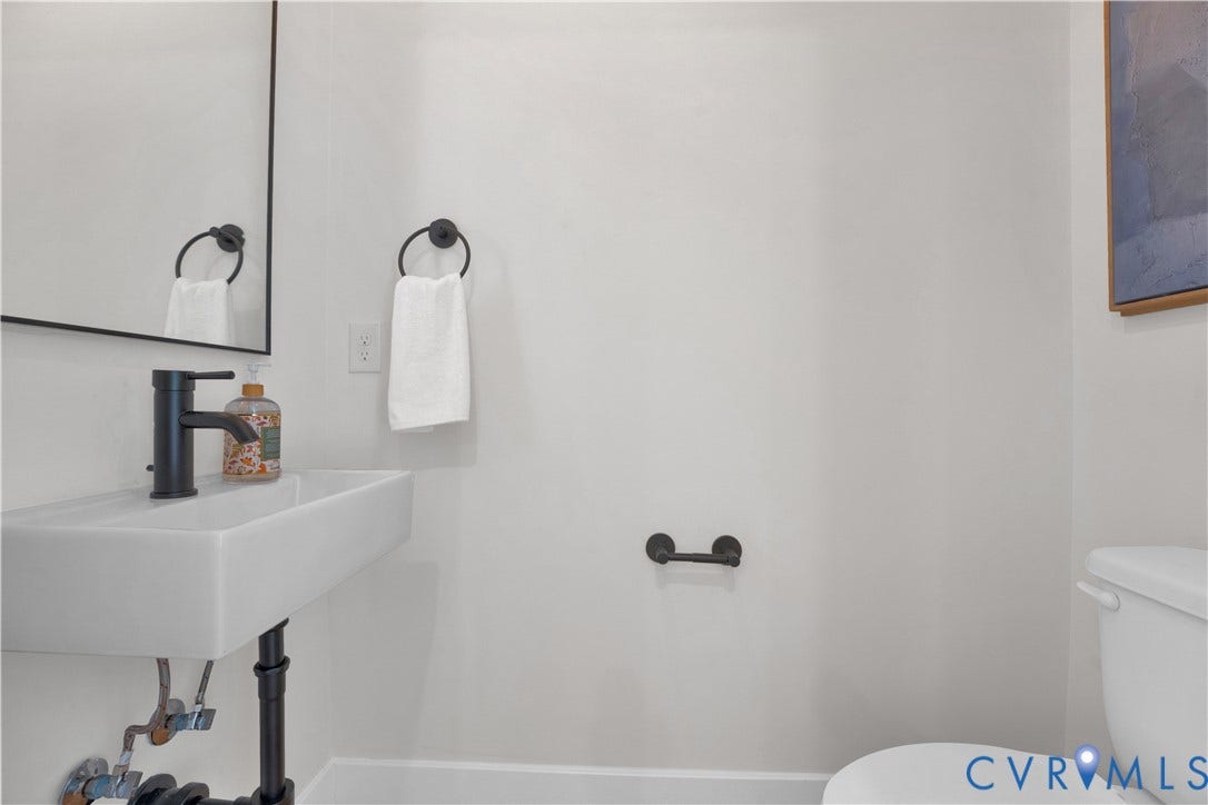 4506 1/2 Grove Avenue, Munford On Grove, Richmond, VA 23221 Wall-mounted rectangular sink with matte black faucet, framed mirror, and coordinating matte black towel ring