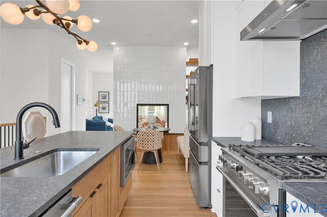 4506 1/2 Grove Avenue, Munford On Grove, Richmond, VA 23221 Modern kitchen featuring light wood cabinetry, stainless steel appliances, dark countertops, and a contemporary chandelier