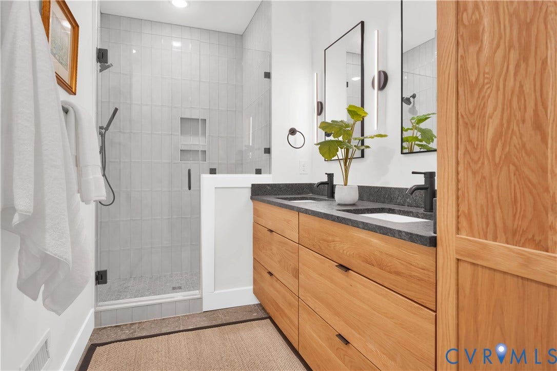 4506 1/2 Grove Avenue, Munford On Grove, Richmond, VA 23221 Contemporary bathroom featuring a dual vanity with light wood-finish cabinetry, dark stone countertop, and matte black fixtures