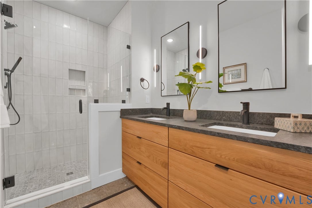 4506 1/2 Grove Avenue, Munford On Grove, Richmond, VA 23221 Modern bathroom featuring a double vanity with wood-finish cabinetry, dark stone countertops, and rectangular undermount sinks with matte black fixtures
