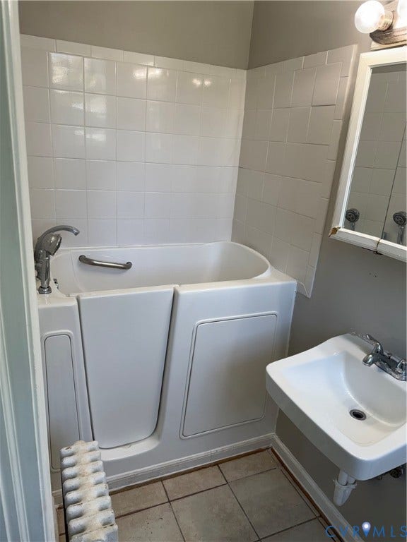 3118 Barton Avenue, Brookland Park, Richmond, VA 23222 First floor bathroom Walk-in tub with grab bar, wall-mounted sink, ceramic tile flooring, and wall-mounted vanity light fixture