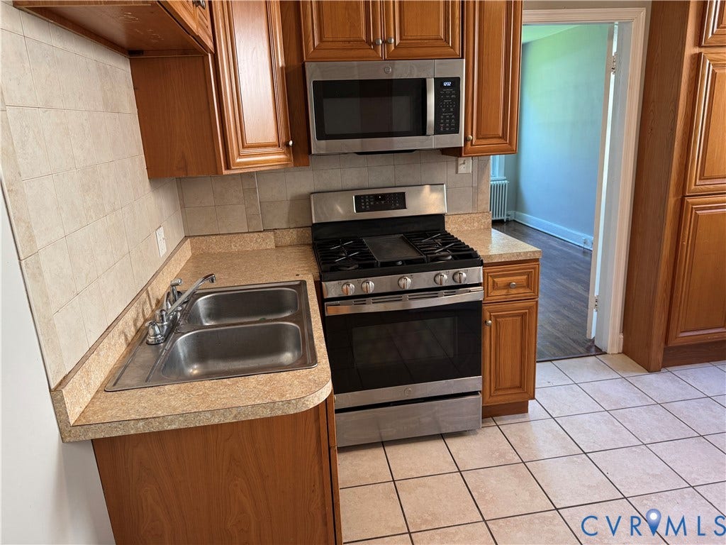 3118 Barton Avenue, Brookland Park, Richmond, VA 23222 Kitchen featuring wood-finish cabinetry, stainless steel appliances, a double basin sink, tile backsplash, and tile flooring