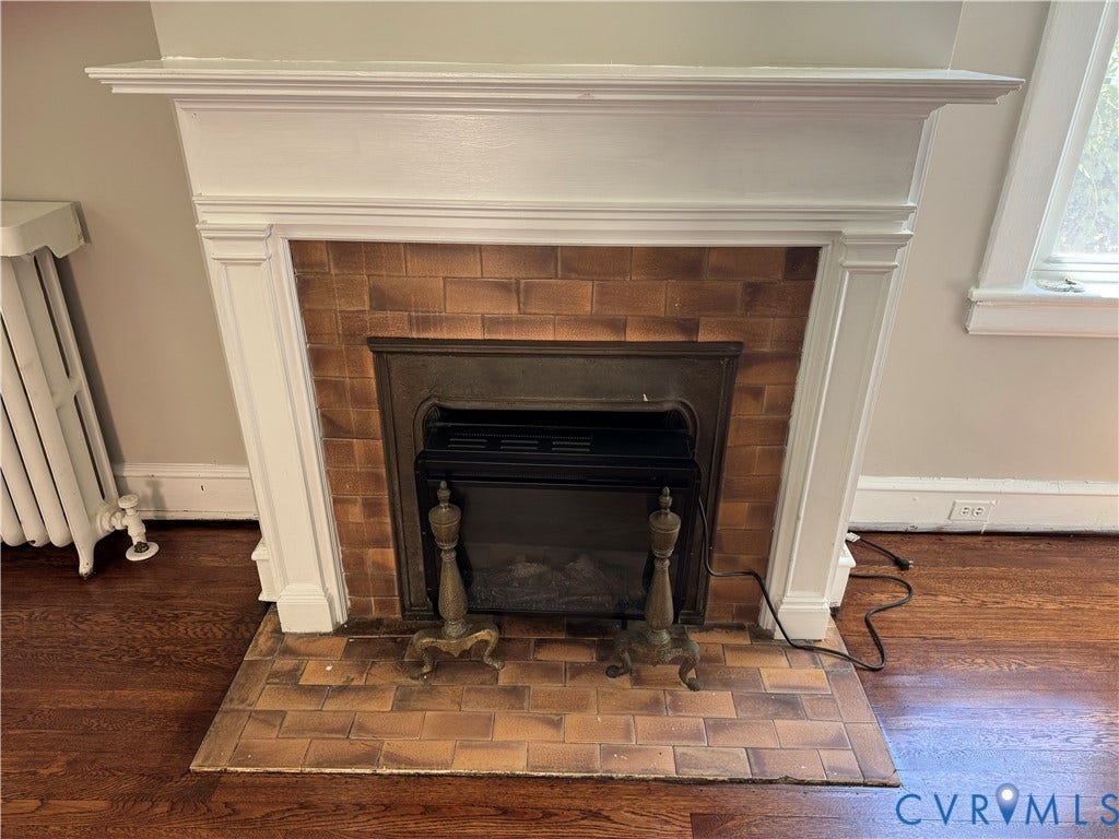 3118 Barton Avenue, Brookland Park, Richmond, VA 23222 White mantel with decorative trim, brick-tiled fireplace surround, integrated firebox, and wood-finish flooring