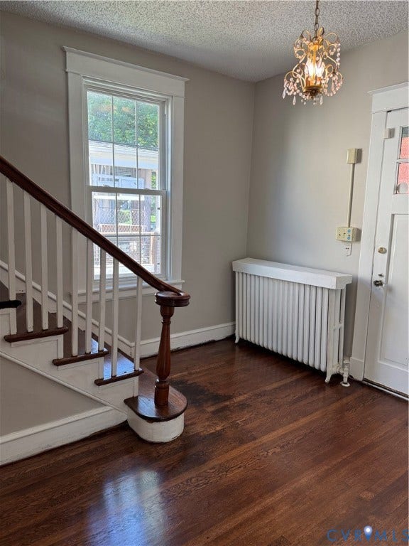 3118 Barton Avenue, Brookland Park, Richmond, VA 23222 Hardwood flooring, classic staircase with wood banister, decorative chandelier, window with white trim, and a radiator