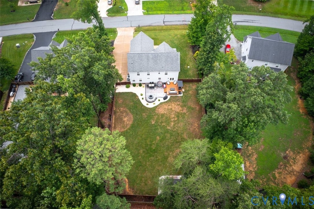 9081 Deerlake Drive, Charming, New Kent, VA 23124 Expansive backyard featuring a large green space, mature trees, and a wooden privacy fence
