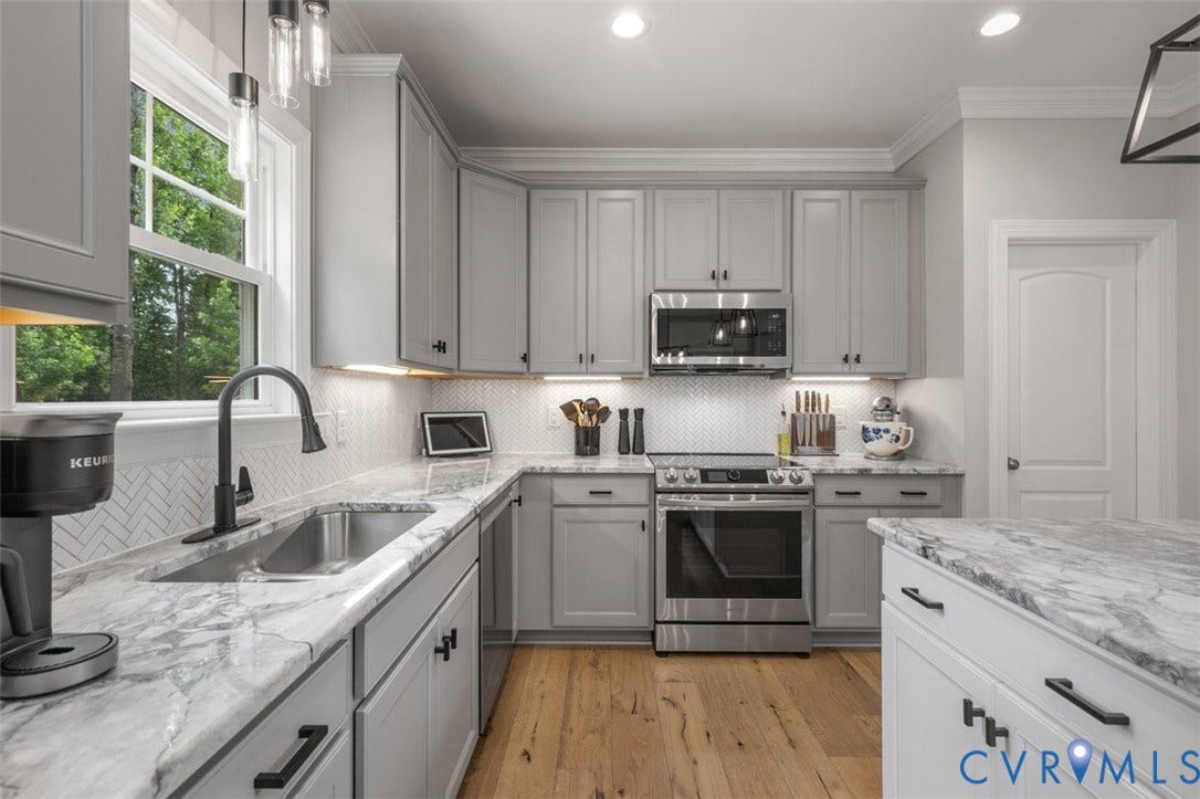 9081 Deerlake Drive, Charming, New Kent, VA 23124 Kitchen featuring light gray cabinetry with black hardware, wood-finish flooring, stainless steel appliances, and light-toned countertops