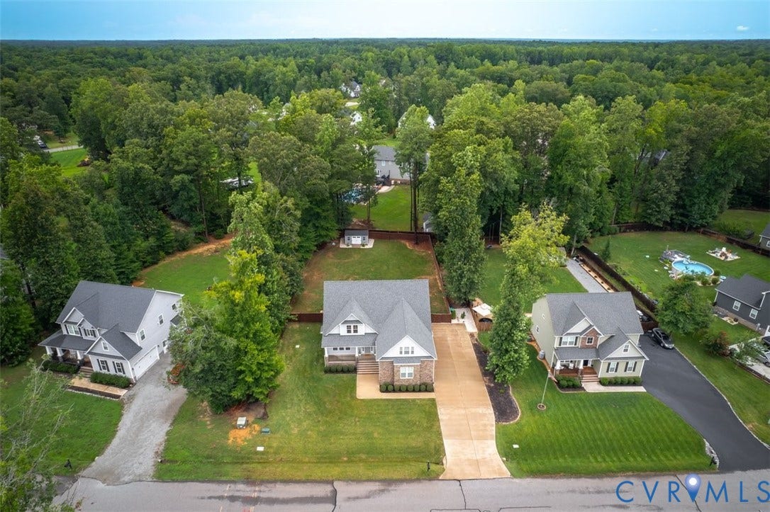 9081 Deerlake Drive, Charming, New Kent, VA 23124 Craftsman - style residence featuring a stone/brick/Hardiplank siding, a gabled roofline, an attached two-car garage, and an extended driveway