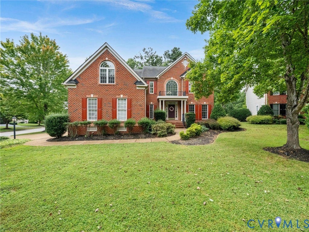 6100 Lilting Branch Way, Moseley, VA 23120 Brick exterior with red shutters, arched entry with balcony, gabled roof, and established landscaping