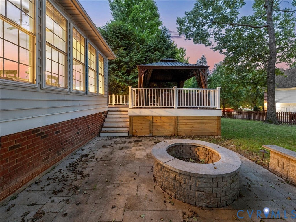6100 Lilting Branch Way, Moseley, VA 23120 Expansive patio with a paver surface and a built-in stone fire pit