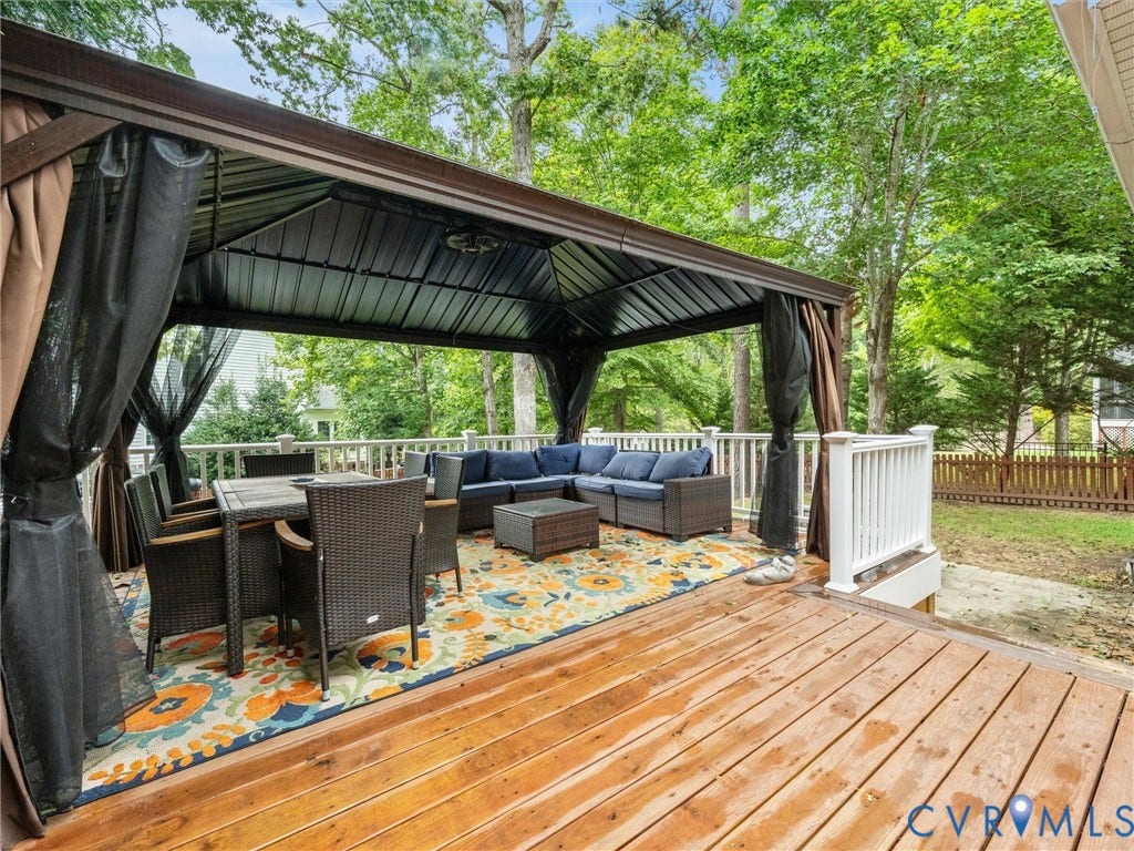 6100 Lilting Branch Way, Moseley, VA 23120 Spacious exterior deck featuring a dark metal gazebo, privacy curtains, and white railings