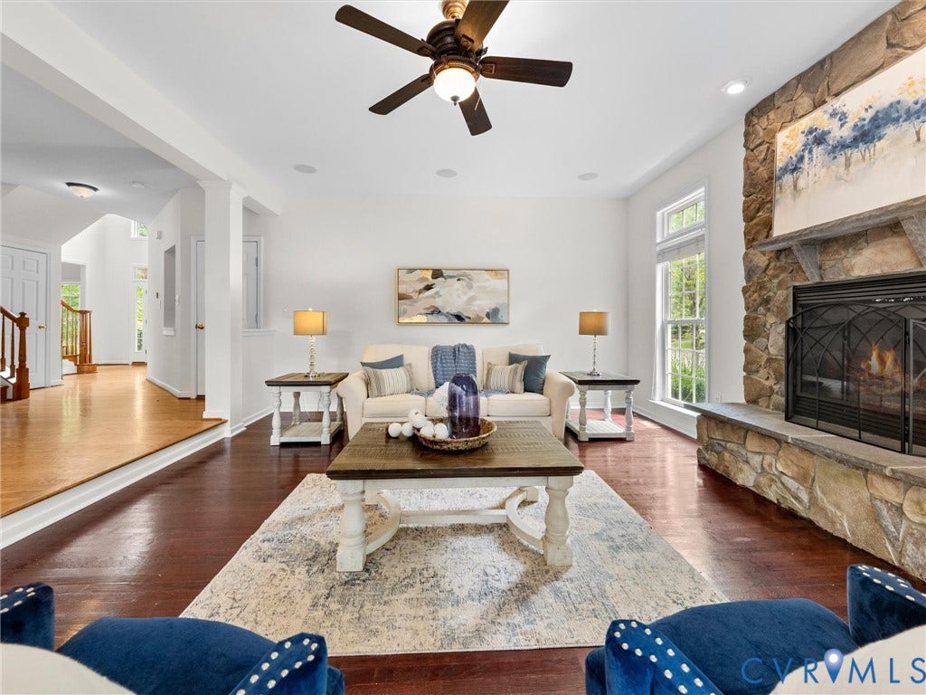 6100 Lilting Branch Way, Moseley, VA 23120 Stone-clad fireplace with hearth, rich wood-finish flooring, recessed lighting, and a ceiling fan