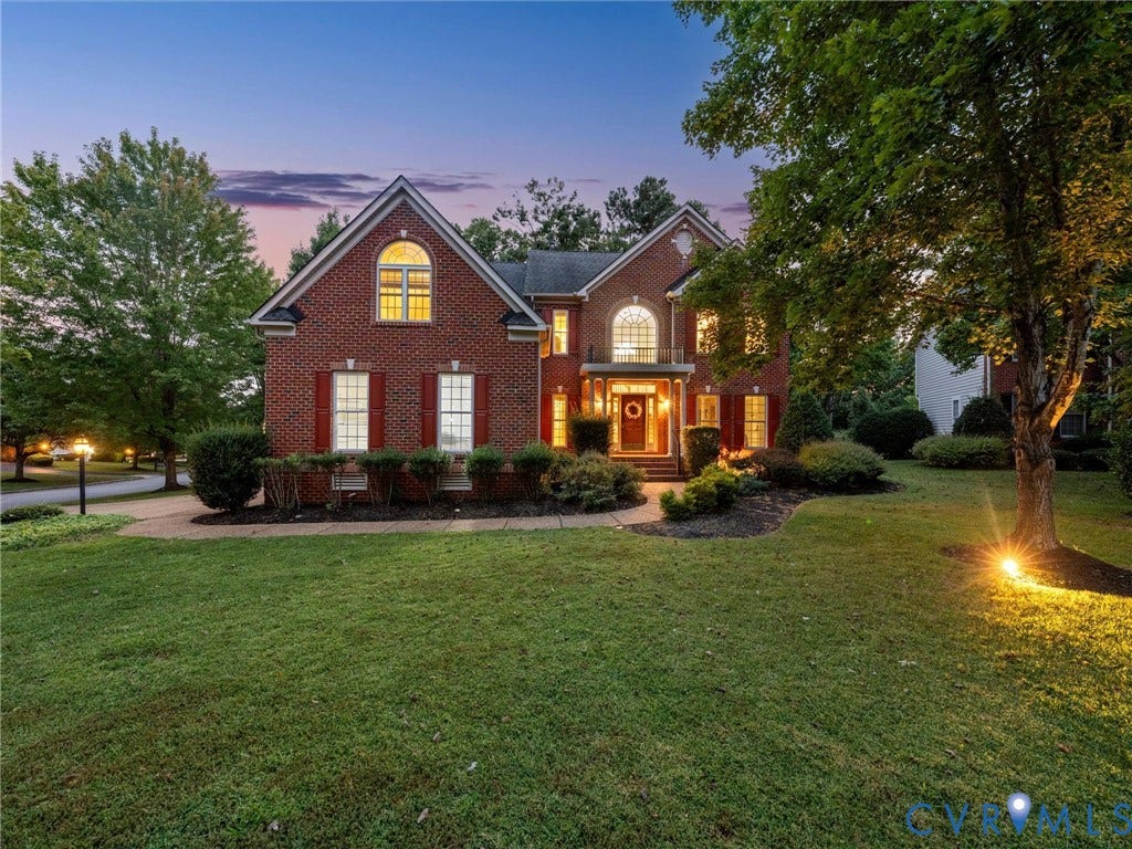 6100 Lilting Branch Way, Moseley, VA 23120 Brick exterior with white window frames and red shutters, featuring a prominent arched window and a covered front entry