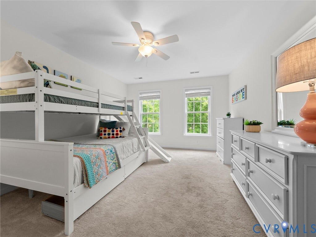 6100 Lilting Branch Way, Moseley, VA 23120 Carpeted flooring, white walls, two windows with blinds, and a ceiling fan with integrated lighting