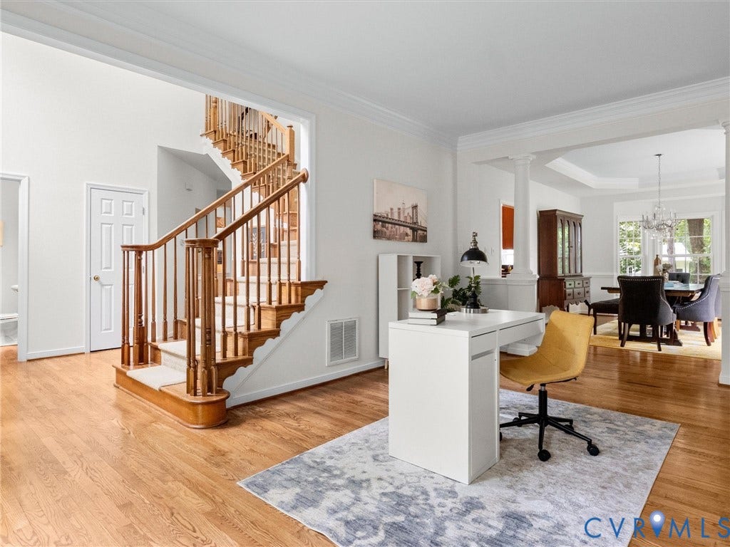 6100 Lilting Branch Way, Moseley, VA 23120 Hardwood flooring, classic wooden staircase with carpeted treads, crown molding, arched entryways, and a tray ceiling