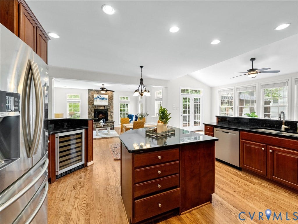6100 Lilting Branch Way, Moseley, VA 23120 Expansive kitchen featuring wood-finish flooring, stainless steel appliances, dark cabinetry, and black countertops