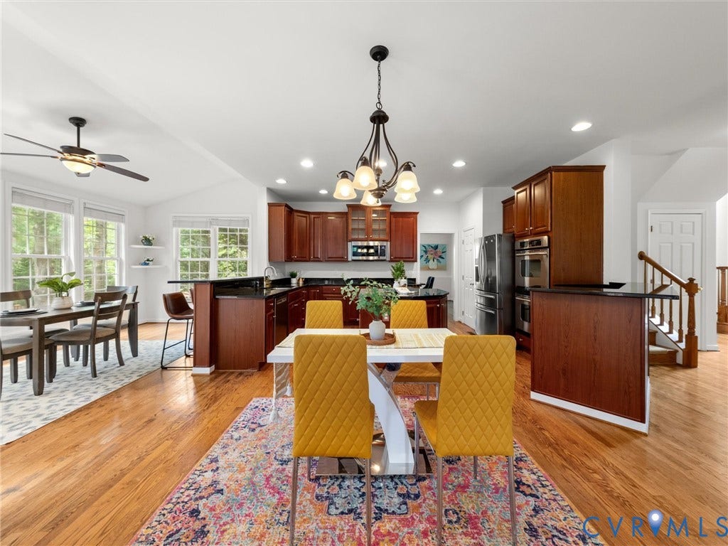 6100 Lilting Branch Way, Moseley, VA 23120 Hardwood flooring throughout, a kitchen featuring dark wood cabinetry, and a double wall oven