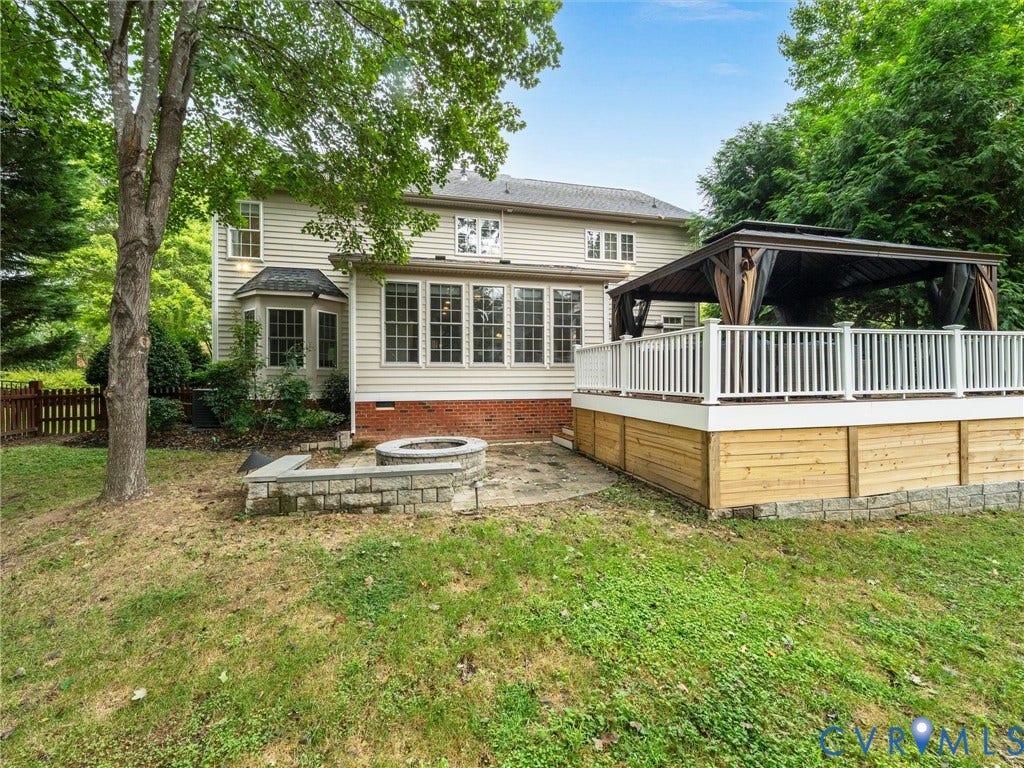 6100 Lilting Branch Way, Moseley, VA 23120 Expansive backyard retreat featuring a two-tier composite deck with white railings, pergola-covered lounge area, and mature tree canopy