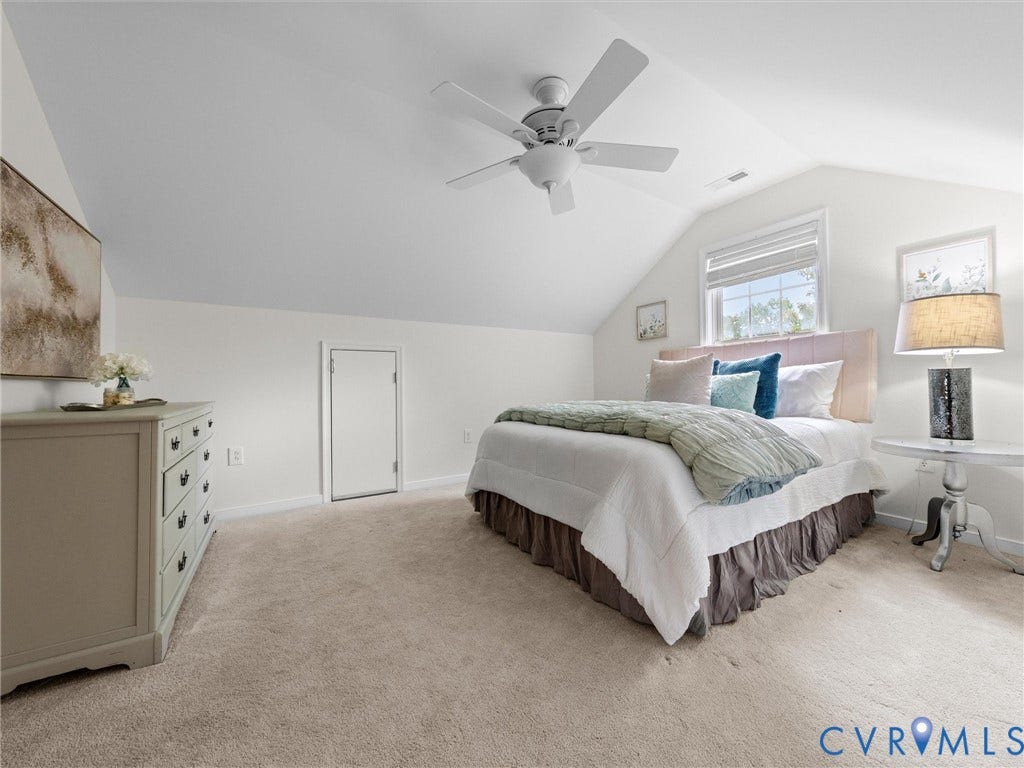 6100 Lilting Branch Way, Moseley, VA 23120 Spacious primary bedroom suite featuring vaulted ceilings, ceiling fan, abundant natural light from multiple windows, neutral carpet flooring, and an attached dresser with drawer storage