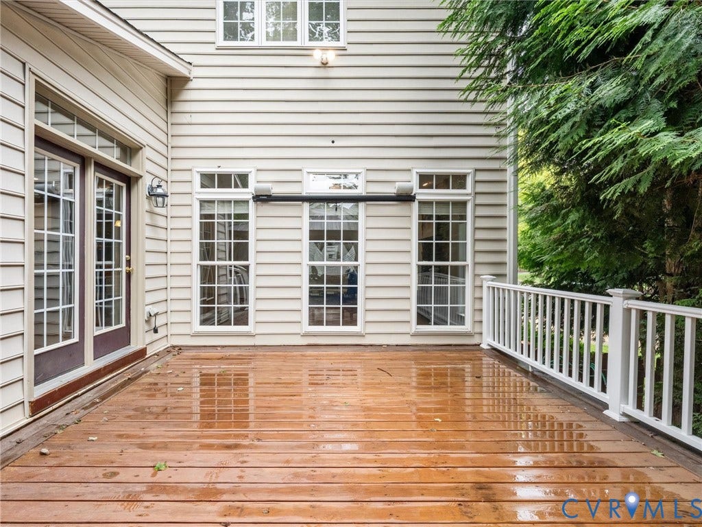 6100 Lilting Branch Way, Moseley, VA 23120 Expansive wood deck with white railing, multiple windows, double glass doors, and cream-colored siding