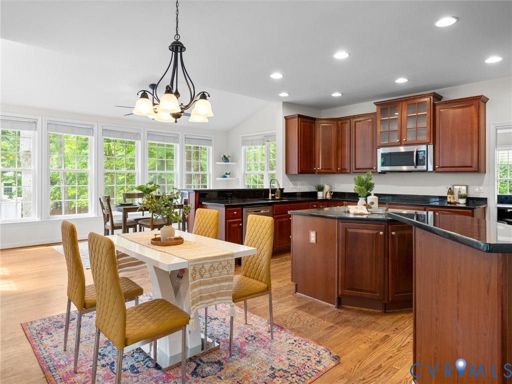 6100 Lilting Branch Way, Moseley, VA 23120 Kitchen and dining area featuring wood-finish flooring, dark wood cabinetry, recessed lighting, and a kitchen island with a dark countertop