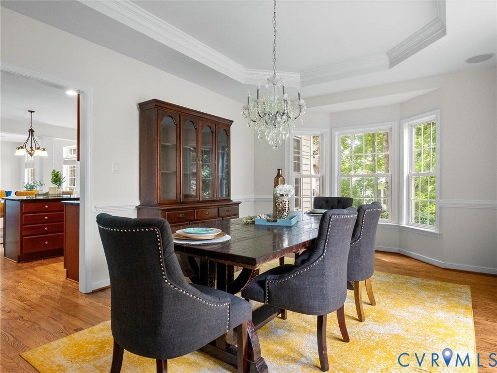 6100 Lilting Branch Way, Moseley, VA 23120 Hardwood flooring, bay window with multiple panes, crown molding, chair rail, and an ornate crystal chandelier