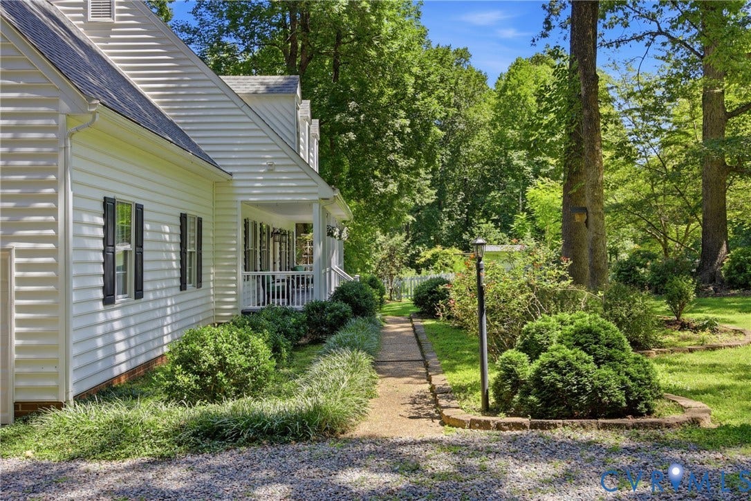 1915 Norwood Creek Drive, Powhatan, VA 23139 White clapboard siding with black window shutters and a covered porch