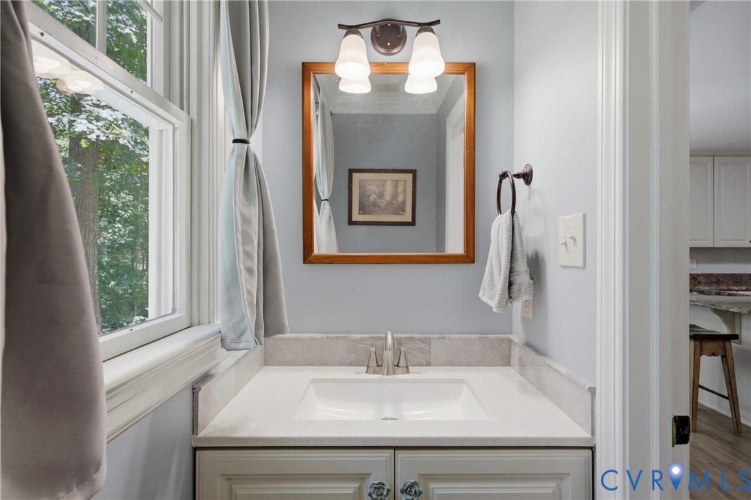 1915 Norwood Creek Drive, Powhatan, VA 23139 Vanity with a white undermount sink, light-toned countertop, and matching backsplash