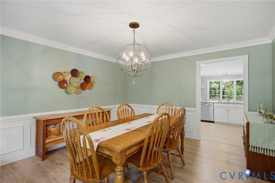 1915 Norwood Creek Drive, Powhatan, VA 23139 Dining area featuring light green walls, wainscoting, crown molding, and wood-finish flooring