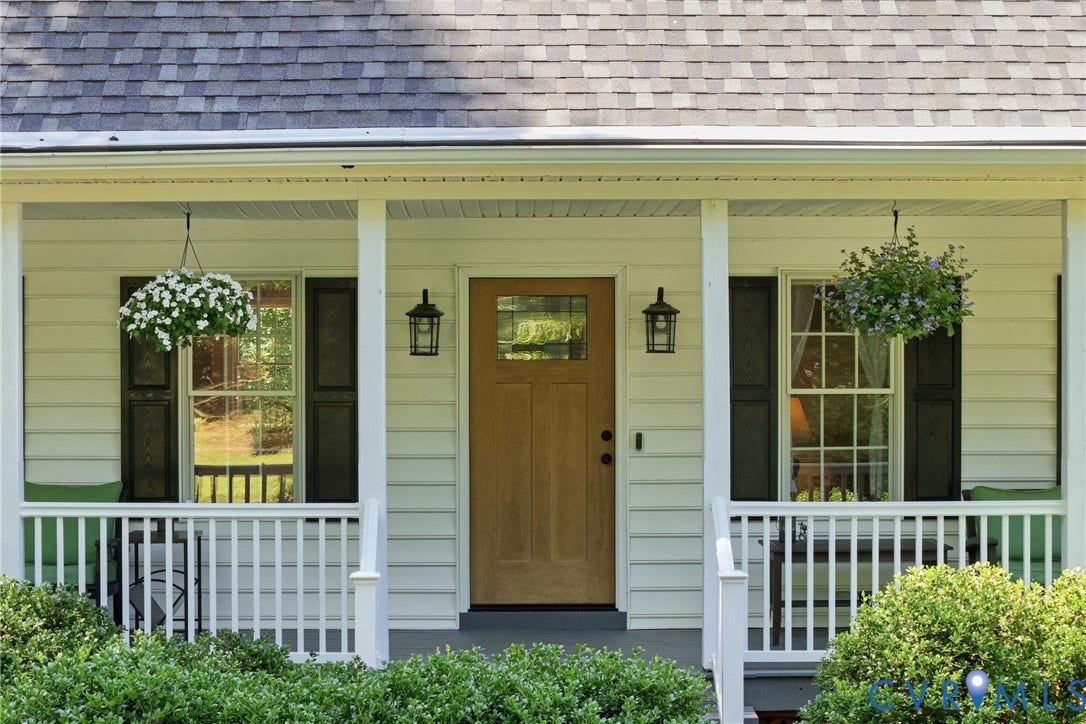1915 Norwood Creek Drive, Powhatan, VA 23139 Inviting front porch featuring white siding, a natural wood-finish door with glass inserts, and black exterior lanterns