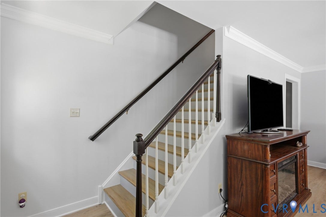 1915 Norwood Creek Drive, Powhatan, VA 23139 Staircase featuring wood-finish treads and risers, dark wood handrail, white balusters, and crown molding