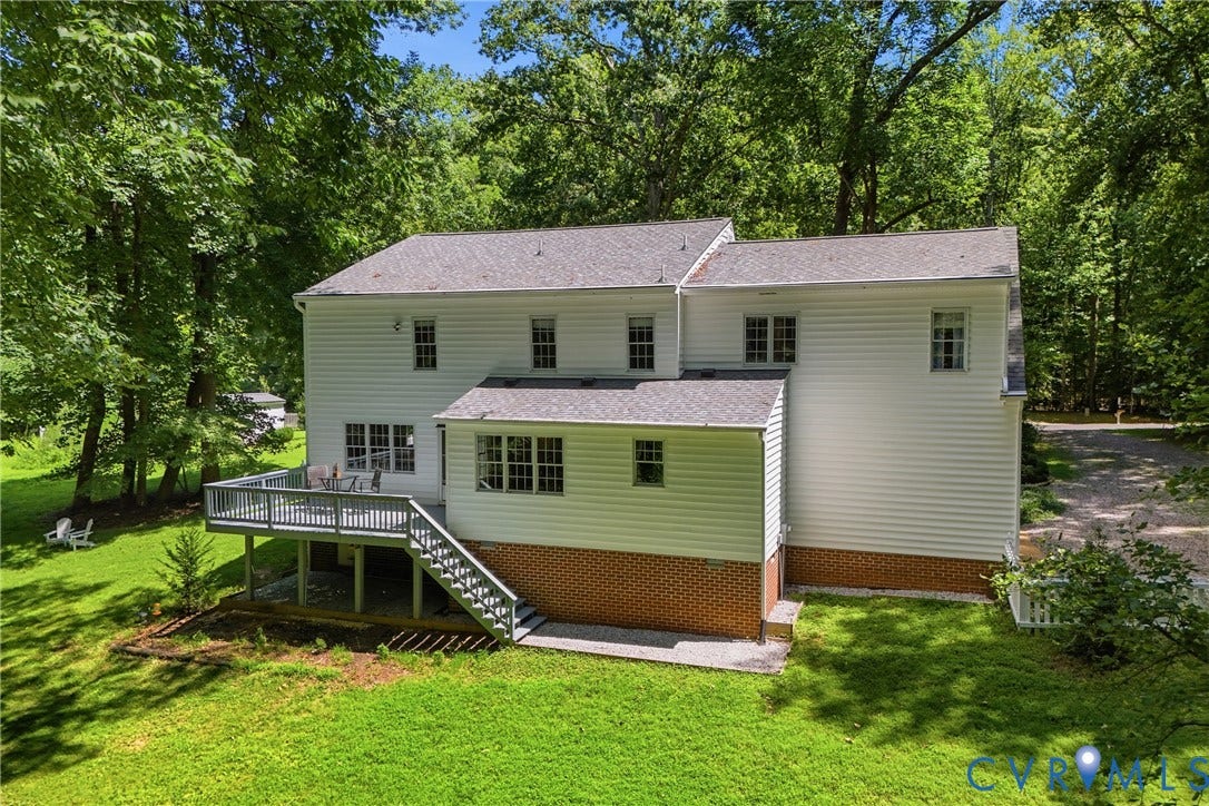 1915 Norwood Creek Drive, Powhatan, VA 23139 White siding exterior with multiple windows, a multi-level roofline, and a spacious rear deck featuring exterior stairs