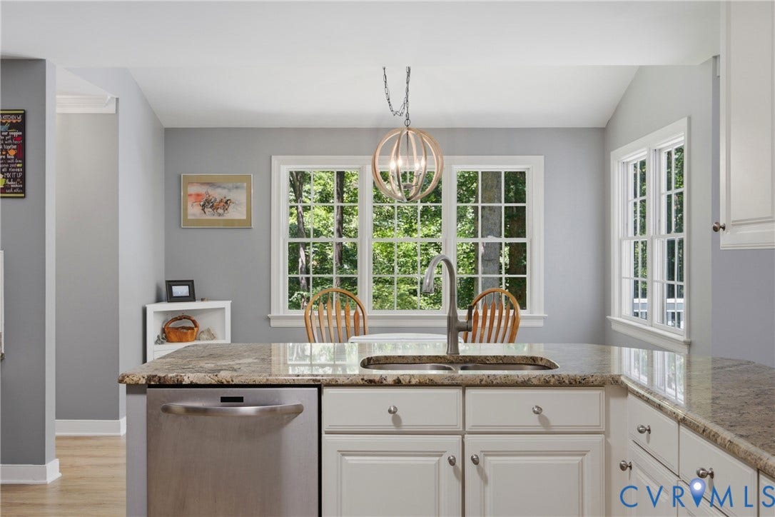 1915 Norwood Creek Drive, Powhatan, VA 23139 Kitchen island featuring a double basin sink with a gooseneck faucet, an integrated stainless steel dishwasher, and a light-toned granite countertop