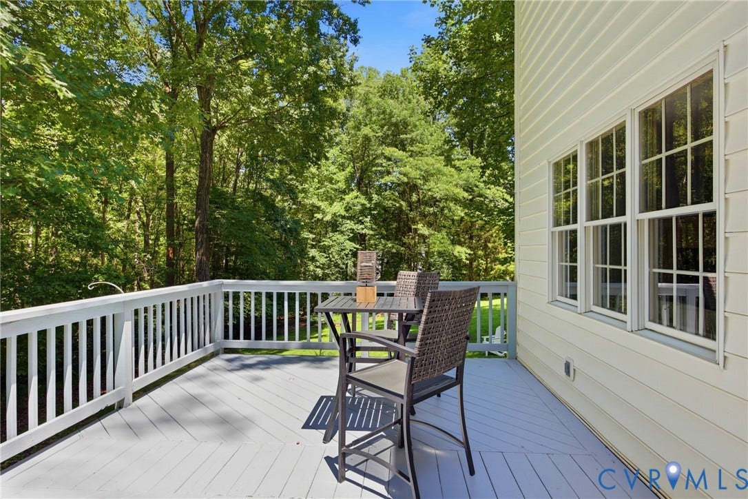 1915 Norwood Creek Drive, Powhatan, VA 23139 Spacious outdoor deck with a light gray finish, surrounded by mature trees