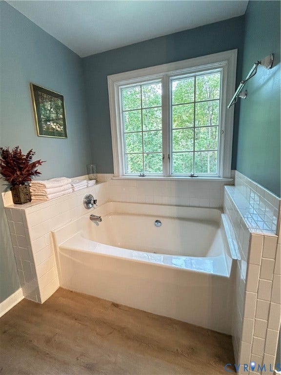 1915 Norwood Creek Drive, Powhatan, VA 23139 Built-in soaking tub with white subway tile surround, chrome fixtures, wood-finish flooring, and a large window