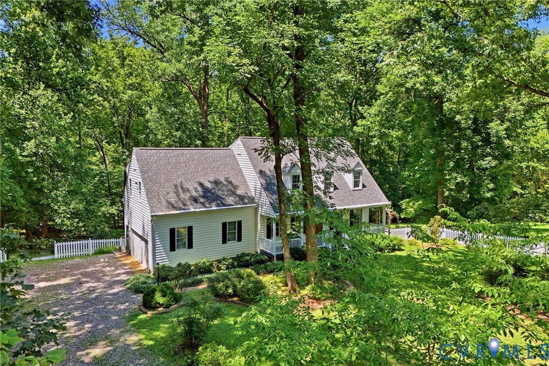 1915 Norwood Creek Drive, Powhatan, VA 23139 White siding residence featuring a dark shingle roof with dormer windows, surrounded by mature trees