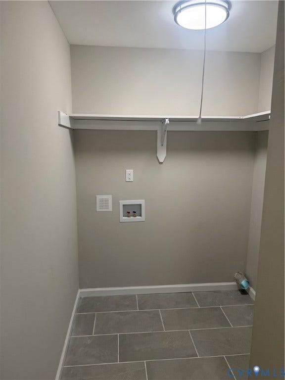 Utility room featuring gray rectangular floor tiles and light neutral wall paint