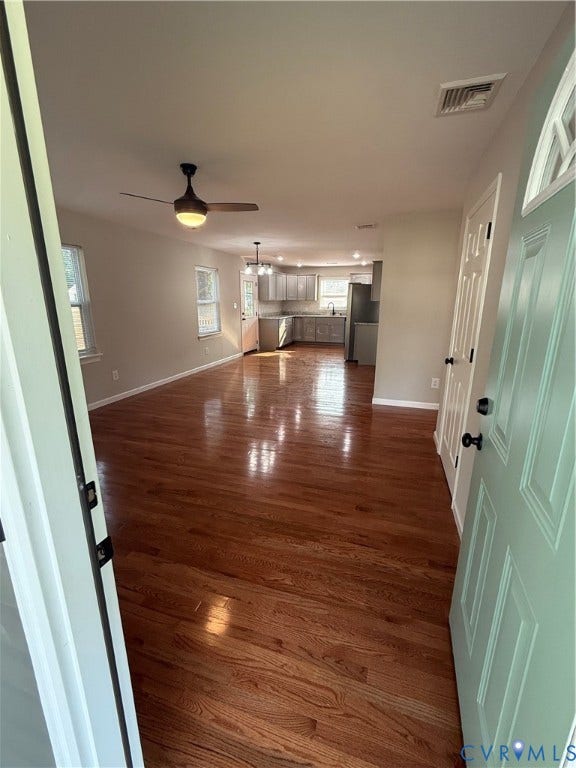 Refinished wood-finish flooring extends throughout the living area into the kitchen