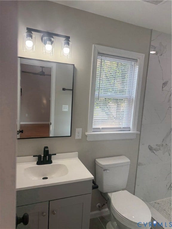 Bathroom featuring a modern vanity with integrated sink, matte black faucet, and white countertop