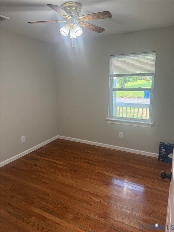 Room featuring wood-finish flooring, neutral wall tones, and white trim