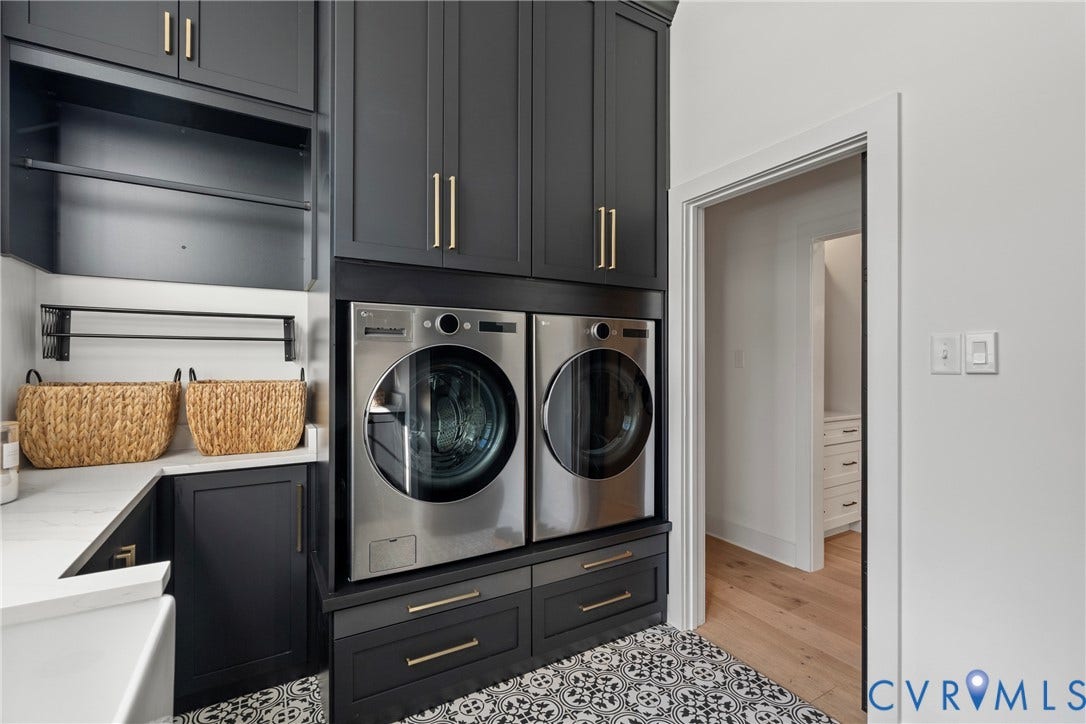 18312 Barrin Court, Barrington, Moseley, VA 23120 Laundry area featuring stacked cabinetry with gold-finish hardware, a white countertop, patterned floor tiling, and a dedicated drying rack