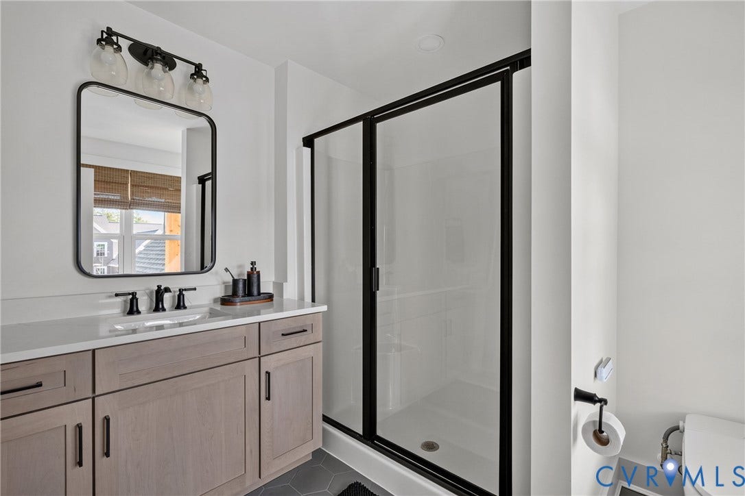 18312 Barrin Court, Barrington, Moseley, VA 23120 Contemporary bathroom featuring a light wood-finish vanity with ample storage, a white countertop, and a rectangular undermount sink