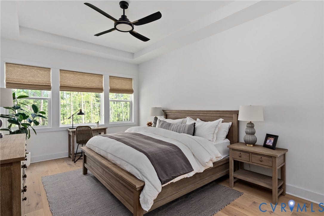 18312 Barrin Court, Barrington, Moseley, VA 23120 Bedroom featuring a tray ceiling, black ceiling fan, wood-finish flooring, and a wall of three windows with woven shades