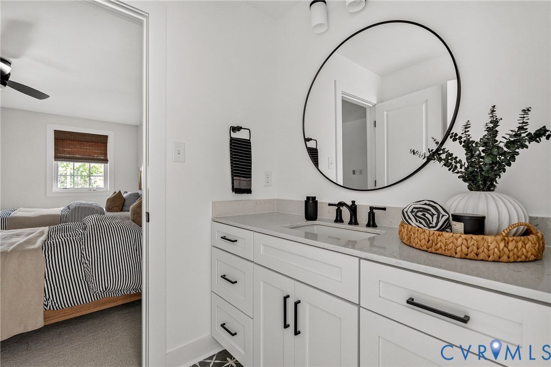 18312 Barrin Court, Barrington, Moseley, VA 23120 Bathroom vanity featuring an undermount sink, matte black faucet, and a large circular mirror