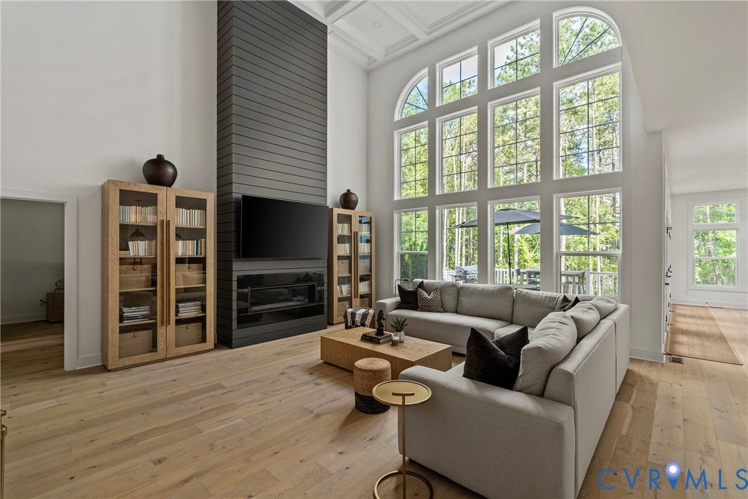 18312 Barrin Court, Barrington, Moseley, VA 23120 Two-story living area featuring extensive window walls with arched transom, a coffered ceiling, a floor-to-ceiling fireplace with a dark paneled surround, and light wood-finish flooring