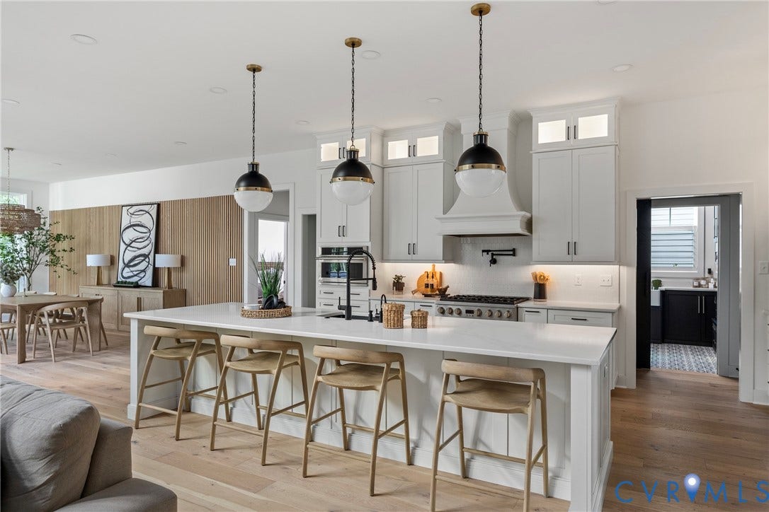 18312 Barrin Court, Barrington, Moseley, VA 23120 Gourmet kitchen featuring a large central island with seating, white shaker cabinetry, pendant lighting, and a stainless steel range