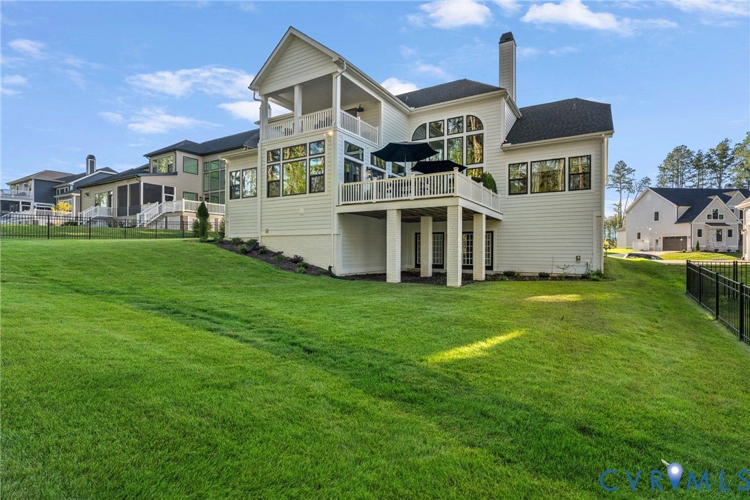 18312 Barrin Court, Barrington, Moseley, VA 23120 Rear exterior featuring a covered upper-level balcony, exposed lower-level patio, and multiple large windows