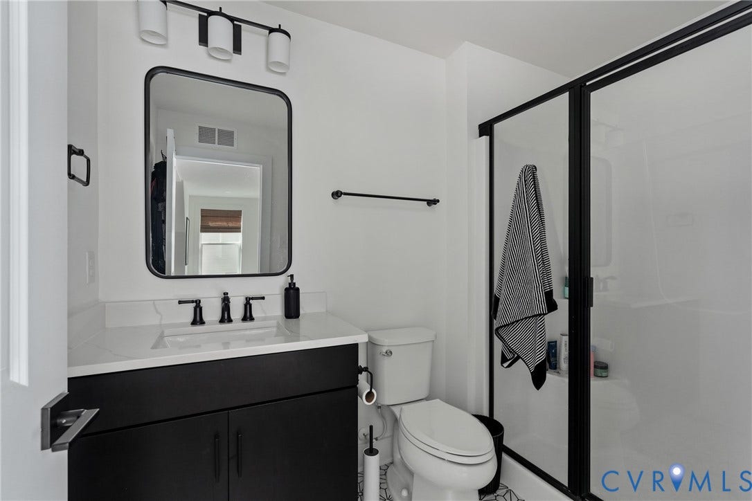 18312 Barrin Court, Barrington, Moseley, VA 23120 Bathroom featuring a contemporary black vanity with a white countertop and undermount sink, a framed rectangular mirror, and a three-light vanity fixture