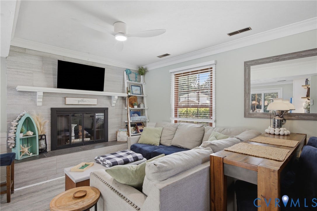 Living area featuring a fireplace with a light-toned tile surround, a white mantel, and a built-in television mount