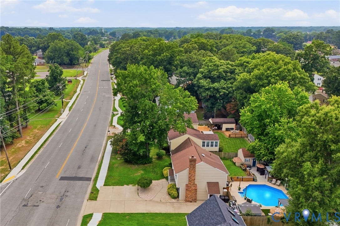 Expansive backyard featuring an in-ground swimming pool, surrounding patio, and a dedicated storage shed